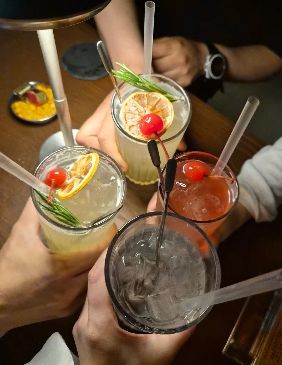四隻手舉著調酒杯碰杯